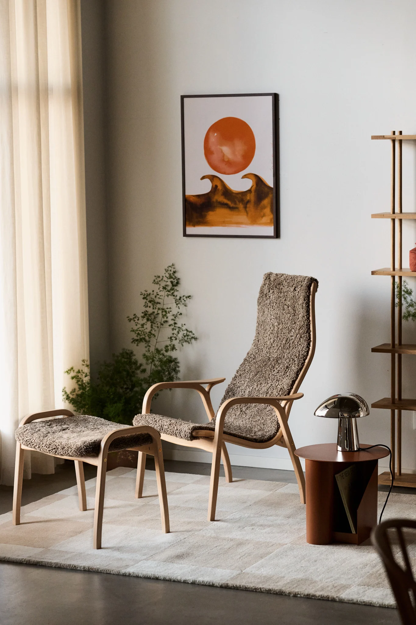A modern lounge chair and ottoman with sheepskin upholstery, a side table with a mushroom lamp, and an abstract art print in a cozy room.