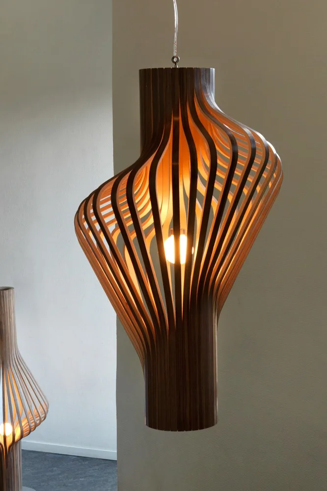 A modern wooden pendant lamp with a spiraling slatted design, glowing warmly.